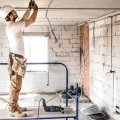 instalador-eletricista-com-uma-ferramenta-nas-maos-trabalhando-com-cabo-no-canteiro-de-obras